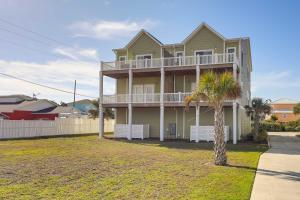 a house with a palm tree in front of it at Emerald Isle Vacation Home Walk to Beach! in Emerald Isle
