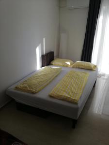 two beds sitting in a bedroom with a window at Apartment by the Sea, Peraia Thessaloniki in Perea