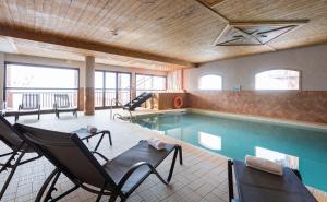 a swimming pool with two chairs and a table at Chalet des Neiges Hermine in Val Thorens