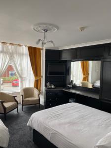 a bedroom with a bed and a desk and chairs at Revelstoke Hotel in Bridlington