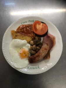 talerz jedzenia śniadaniowego z jajkami, kiełbaskami i tostem w obiekcie Brundholme w mieście Keswick