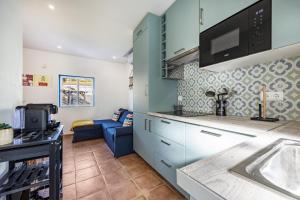 a kitchen with blue cabinets and a blue couch at Salema Beach House in Salema