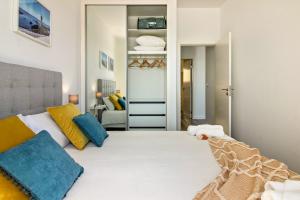 um quarto com uma cama com almofadas azuis e amarelas em Casa Homem do Mar em Paul do Mar