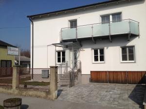 ein weißes Haus mit Balkon darüber in der Unterkunft Gästehaus Karassowitsch in Rust