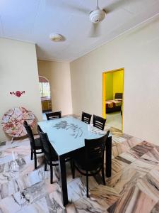 a dining room with a table and chairs at MH Homestay No2 at Alor Setar in Alor Setar
