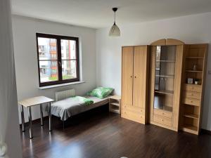 una camera con letto, armadio e tavolo di Tylna 8 Apartments a Łódź