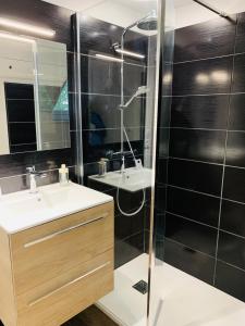 een badkamer met een glazen douche en een wastafel bij Cottage in Missillac