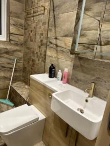 a bathroom with a sink and a toilet at Amazing 4 Bedrooms family home with free parking in Romford