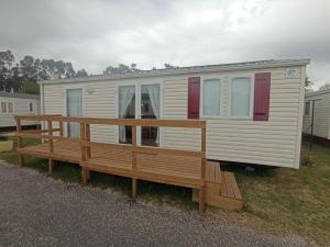 a mobile home with a porch and a wooden deck at Casinhas Do Alentejano - Lands house Bungalows in Burinhosa