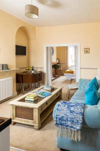 a living room with a blue couch and a table at Ilkley Studio in Ilkley