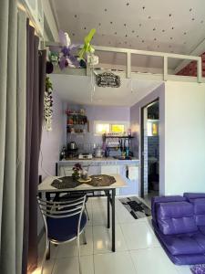 a kitchen and dining room with a table and purple chairs at JC Unit #8 in Urdaneta