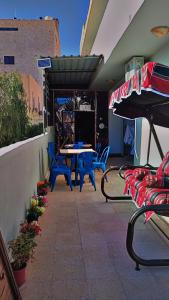 a patio with blue chairs and a table and a patio umbrella at Its your choice hostel in Wadi Musa