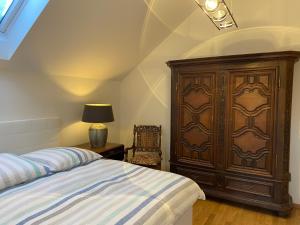 ein Schlafzimmer mit einem großen Holzschrank und einem Bett in der Unterkunft Haus Charlotte in Papstdorf