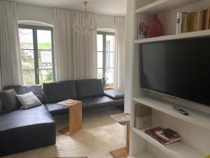 ein Wohnzimmer mit einem Sofa und einem großen Flachbild-TV in der Unterkunft Haus Charlotte in Papstdorf