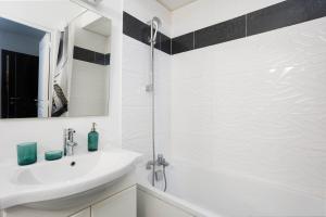 a white bathroom with a sink and a mirror at Charmant Studio à Neuilly-sur-Marne in Neuilly-sur-Marne