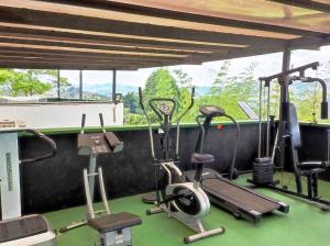 einen Fitnessraum mit Trainingsgeräten vor dem Fenster in der Unterkunft Villa el Paraíso in El Peñol