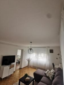 ein Wohnzimmer mit einem Sofa und einem TV in der Unterkunft NO NAME in Koprivnica