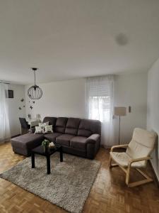 ein Wohnzimmer mit einem Sofa und einem Stuhl in der Unterkunft NO NAME in Koprivnica