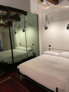 - une chambre avec 2 lits et un grand miroir dans l'établissement VIA BRASCHI SESSANTASEI, à Cesena