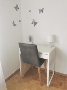 einen Schreibtisch mit einem Stuhl und einem weißen Schreibtisch mit Schmetterlingsdecalen in der Unterkunft NO NAME in Koprivnica