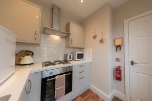 a kitchen with a stove and a microwave at Kelvin House in Fleetwood