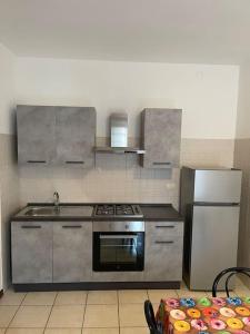 巴斯卡迪的住宿－Residenza il Ciliegio，厨房配有不锈钢炉灶和冰箱。