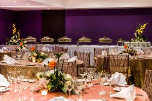 un conjunto de mesas en una habitación con paredes púrpuras en Lidotel Margarita, en Pampatar