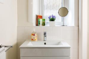 a white sink in a bathroom with a window at Ilkley Studio in Ilkley
