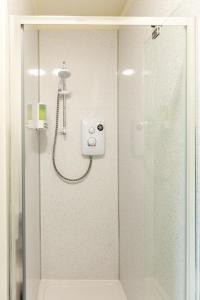 een douche in een badkamer met een glazen deur bij Ilkley Studio in Ilkley