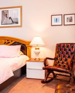 a bedroom with a bed and a chair and a lamp at Kelvin House in Fleetwood