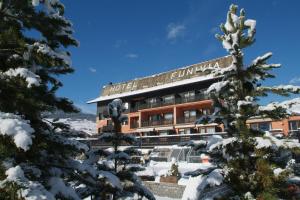 
a large building with a snow covered porch and trees at Hotel Funivia in Bormio

