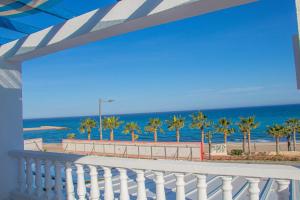 モハカルにあるLa Esperanza Beach- Zona Pubs y Restaurantesのビーチとヤシの木の景色を望むバルコニー