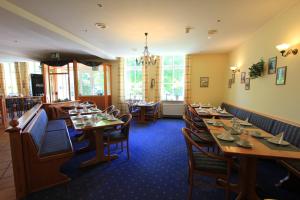 une salle à manger avec des tables et des chaises en bois dans l'établissement Residenzia Hotel Grenadier, à Munster im Heidekreis