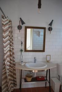 W łazience znajduje się umywalka i lustro. w obiekcie Monte Ramos w mieście Ferreira do Alentejo