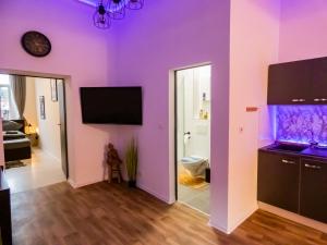 uma sala de estar com paredes roxas e uma televisão de ecrã plano em #221 Moderne City Wohnung im Herzen von Neuss em Neuss