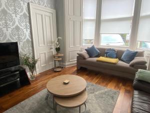 a living room with a couch and a table at Lovely main door 2 bed apartment in Edinburgh