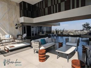 a living room with a couch and chairs on a patio at Luxury Condo in Lobby33 near Andares By Bamboo in Guadalajara