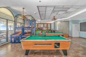 uma sala de jogos com mesas de bilhar e jogos de arcada em Sun N Sand 607 em Myrtle Beach