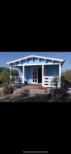 une maison bleue et blanche avec une terrasse couverte dans l'établissement Kalma experiencias turísticas, à Cadix