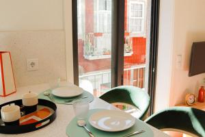 une table avec des assiettes et des ustensiles et une fenêtre dans l'établissement Fish Village Deluxe, à Vila Nova de Gaia