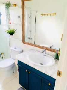 een badkamer met een wastafel, een toilet en een spiegel bij Bellavista V Cabo Roig in Cabo Roig