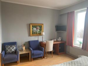 a bedroom with a desk and two chairs and a desk and a bed at Horten Budget Hotel in Horten