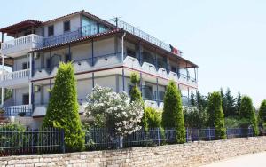 un gran edificio blanco con árboles delante de él en Villa Mondi, en Ksamil