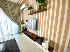 a living room with a television on a striped wall at Royal Strand Danga Bay Abang Payung in Johor Bahru