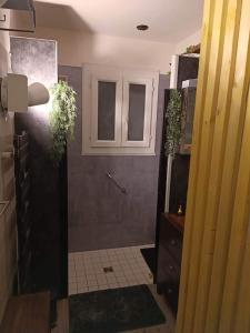 La salle de bains est pourvue d'une douche et d'une porte ornée de plantes. dans l'établissement House 3km from the 24 Hours of Le Mans circuit, à Ruaudin