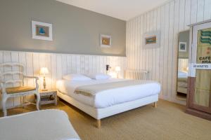 a hotel room with two beds and a chair at L'Hippocampe in La Flotte