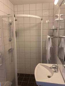 a white bathroom with a sink and a shower at Horten Budget Hotel in Horten