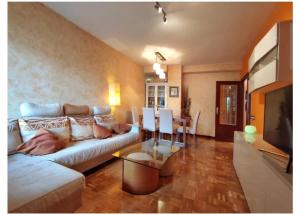 a living room with a couch and a dining room at Apartamento La Rocha, con garaje cerca del centro, Pamplona in Pamplona