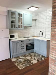 eine Küche mit weißen Schränken, einer Spüle und einem Kühlschrank in der Unterkunft Bonito apartamento con vistas al mar in Las Negras