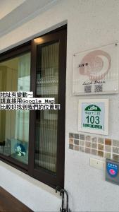 a building with a door and a sign on it at Lucid Dream清醒夢民宿 in Yilan City